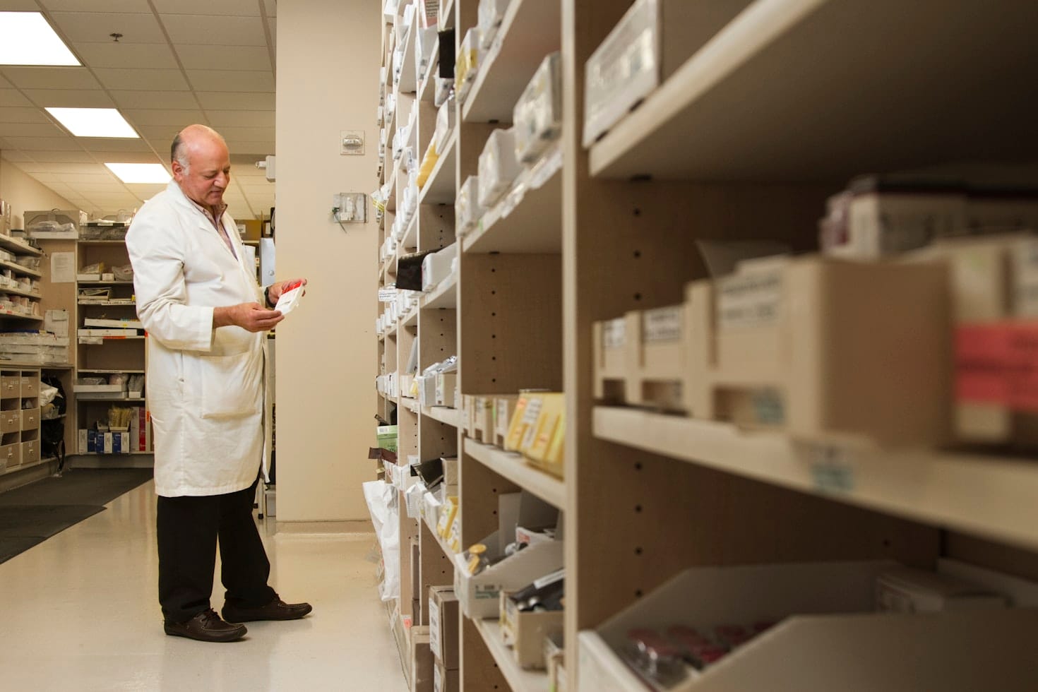 A pharmacist inspecting and organizing pharmaceutical supplies